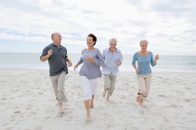 Four elders running on the beach. alert1 medical alert system